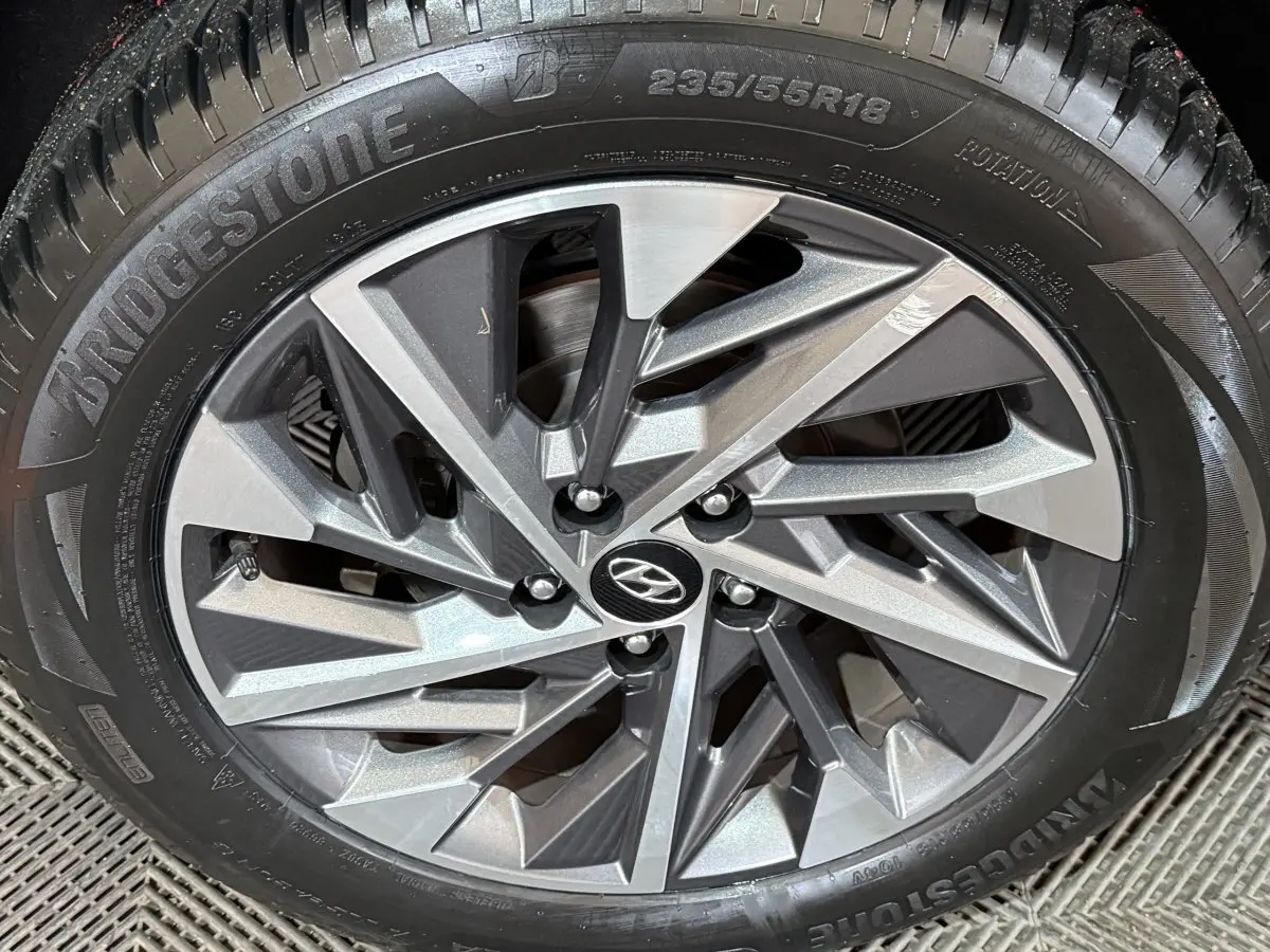 Gros plan sur la jante alliage gris et noir du Hyundai Tucson 2021, pneu Bridgestone visible.
