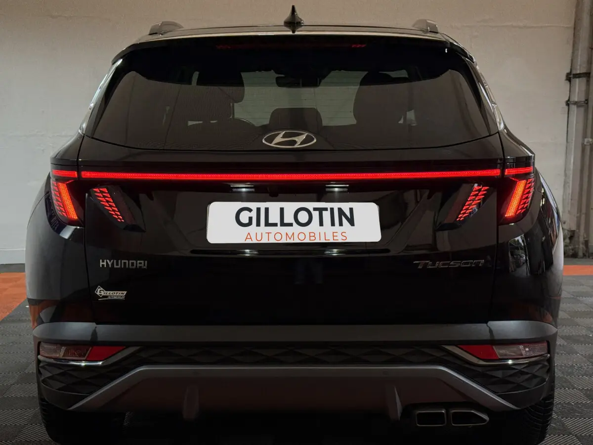Vue arrière d'un Hyundai Tucson noir 2021 avec feux LED en bandeau et double sortie d'échappement carrée.