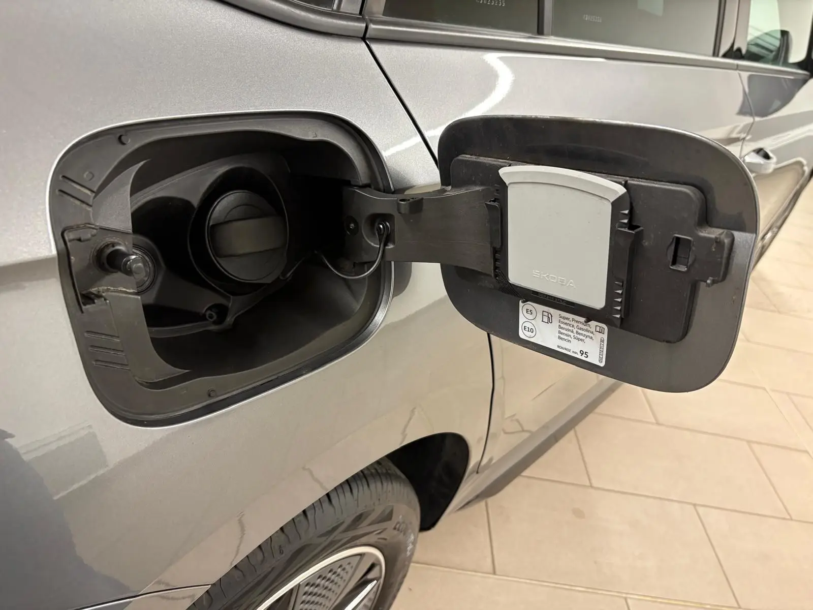 Détail de la trappe à carburant ouverte côté gauche sur un Skoda Kamiq 1.5 TSI 150 DSG7 Monte Carlo gris graphite 2024.