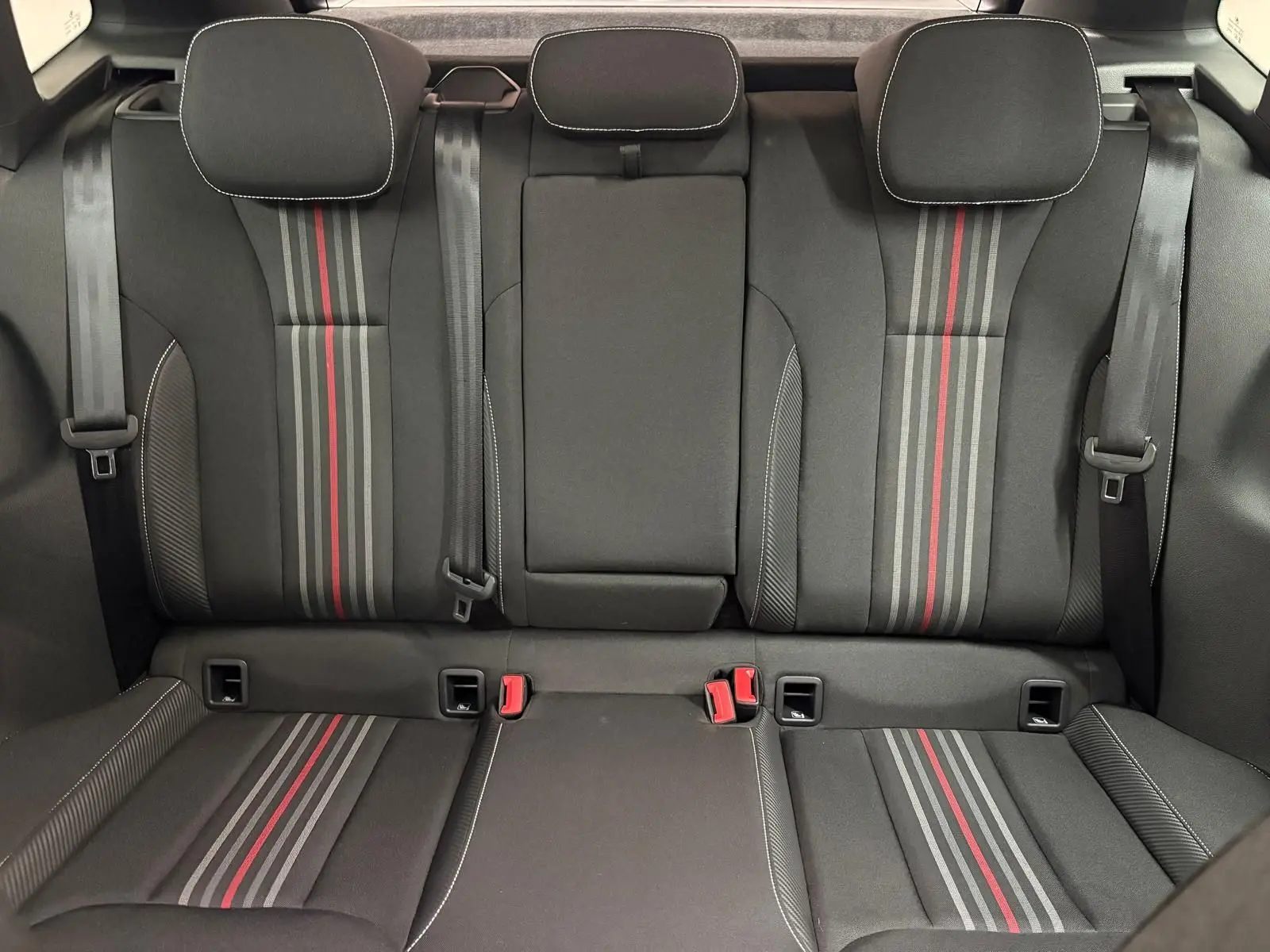 Vue intérieure arrière des sièges noirs avec bandes grises et rouges du Skoda Kamiq Monte Carlo 2024 en gris graphite.