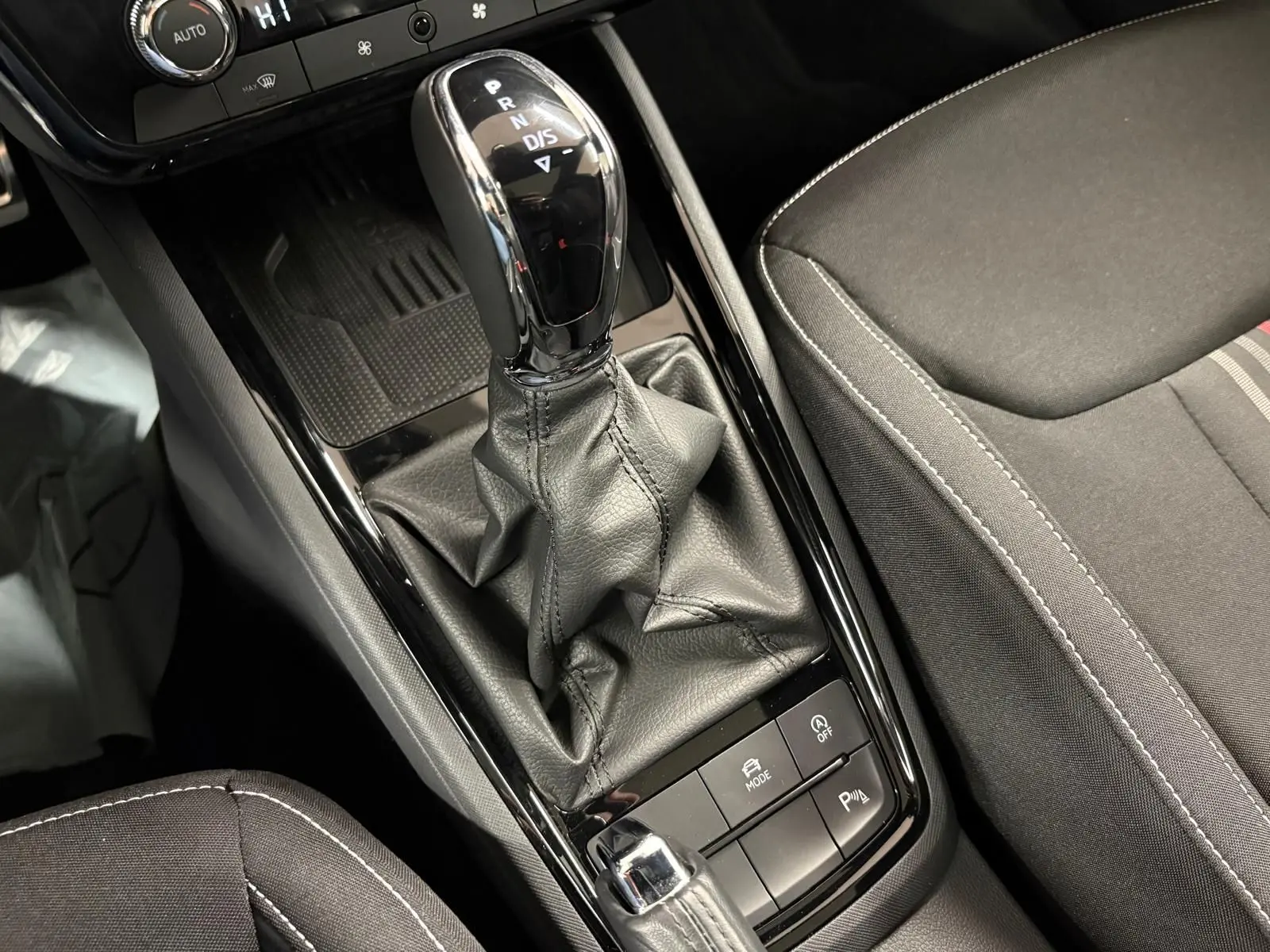 Le levier de vitesses automatique noir et chrome du Skoda Kamiq Monte Carlo 2024, avec console et siège gris graphite.