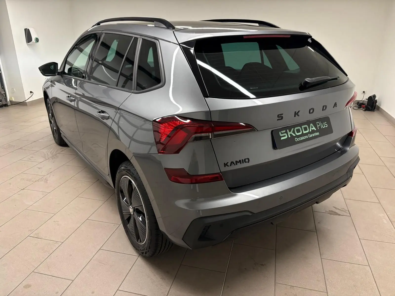 Vue 3/4 arrière droite du Skoda Kamiq Monte Carlo 2024 en gris graphite avec jantes noires distinctives.