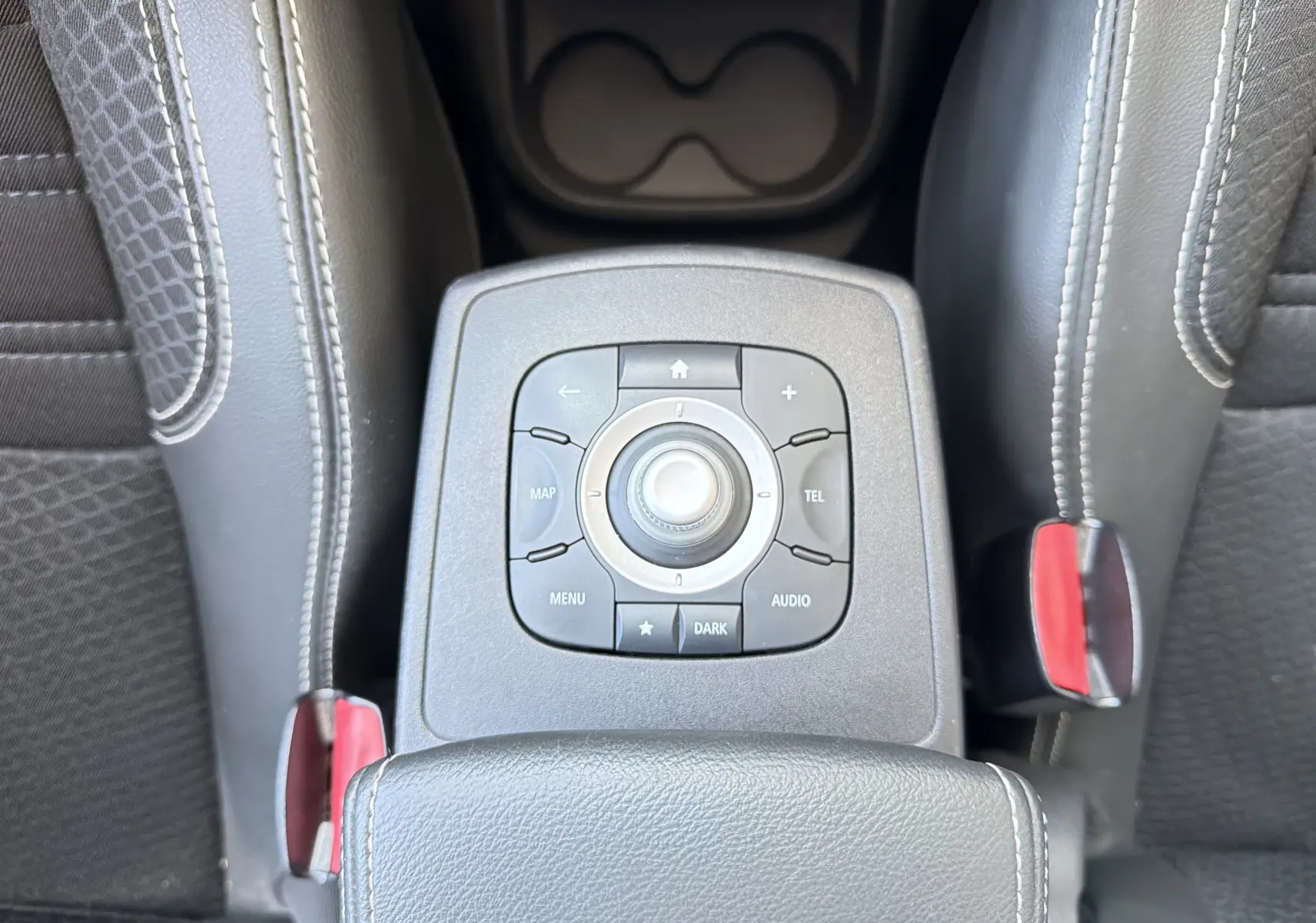 Vue plongeante sur la console centrale du Renault Scénic 1.5 dCi 110 Bose, avec commandes multimédia et sellerie noire.