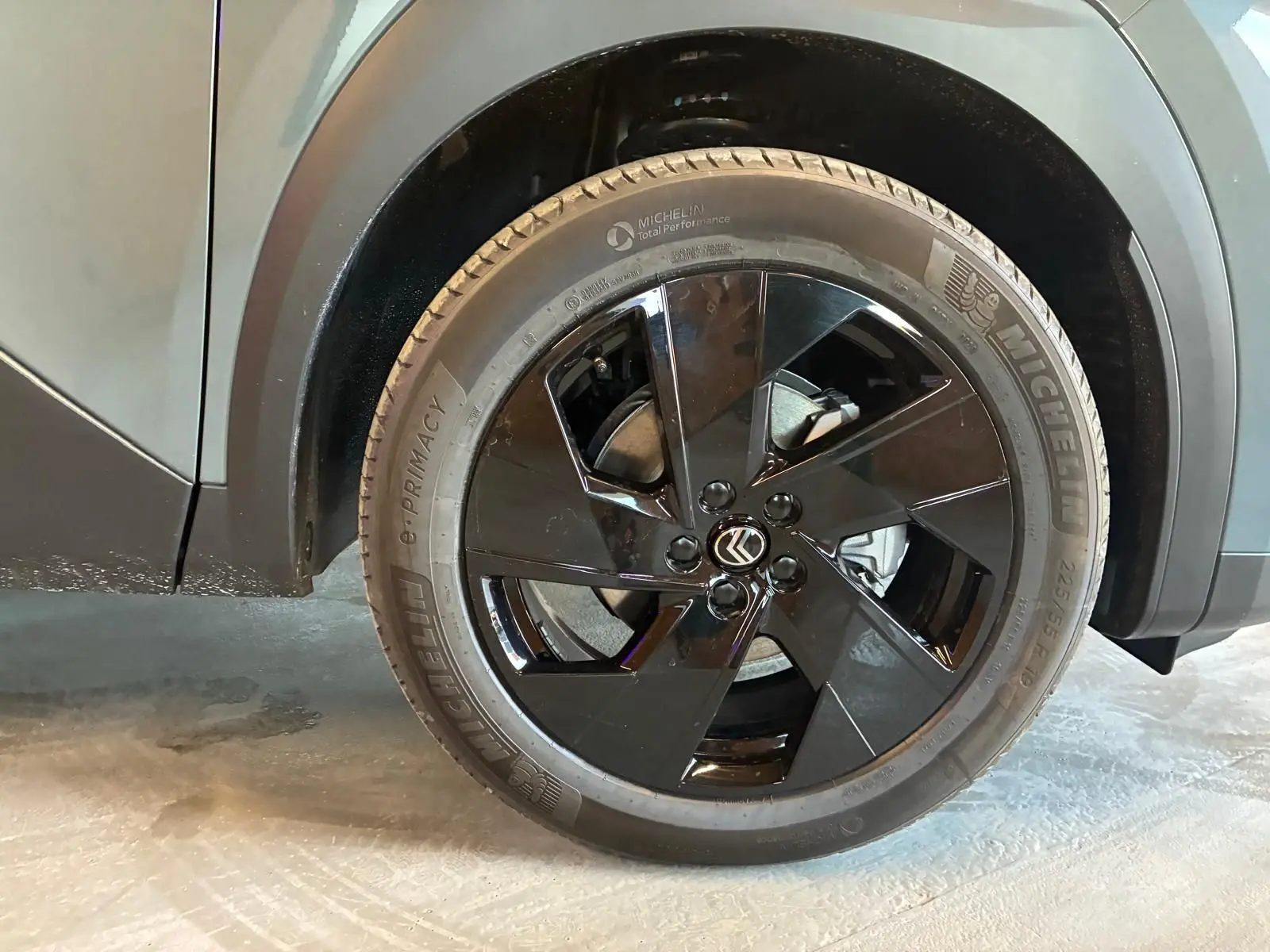 Gros plan sur la roue avant gauche noire brillante du Citroën C5 Aircross vert Astoria Metal, avec logo Citroën au centre.