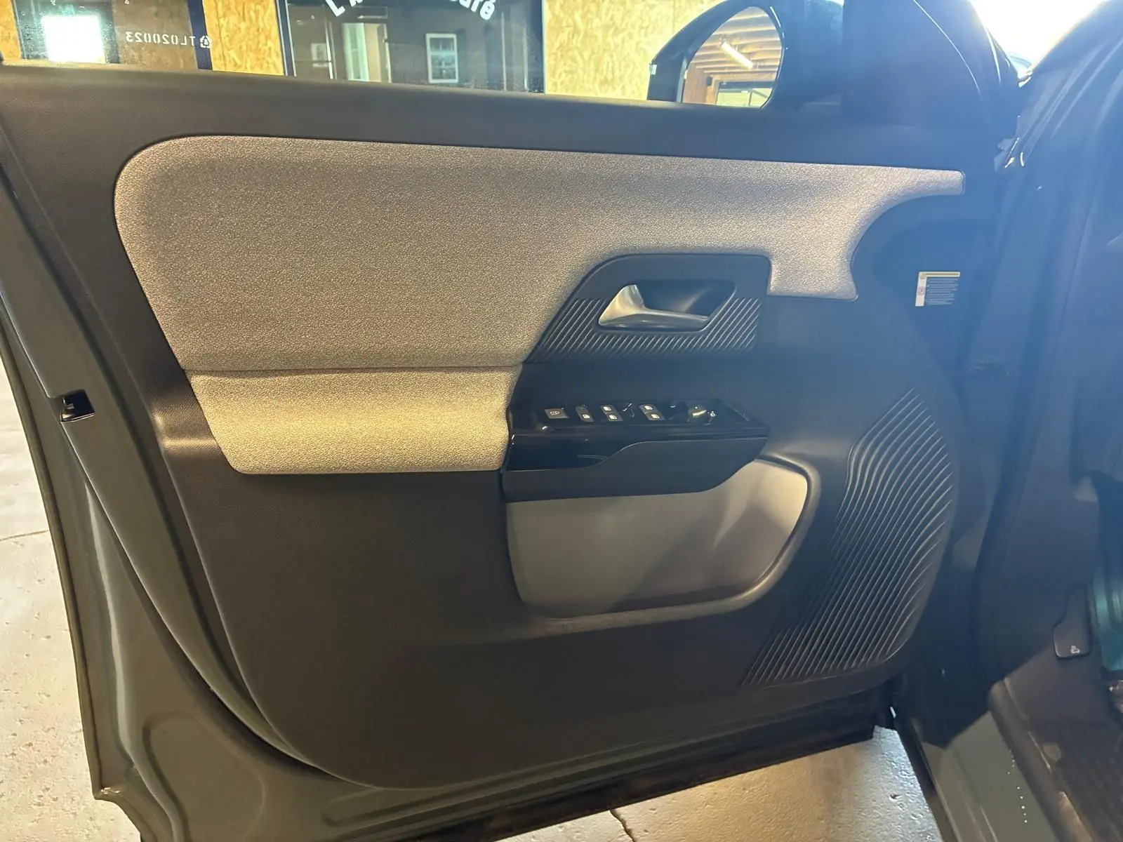 Vue intérieure côté gauche de la porte avant du Citroën C5 Aircross 2026, avec panneau bicolore gris clair et noir.
