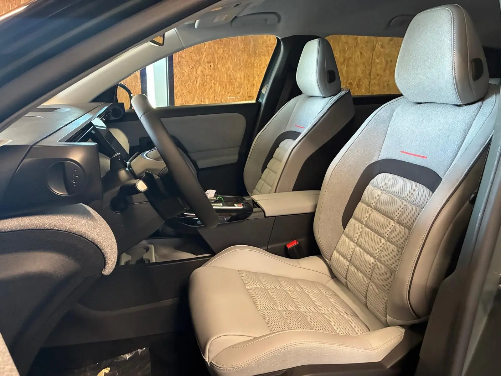 Vue intérieure côté gauche du Citroën C5 Aircross 2026, sièges gris clair avec surpiqûres rouges et volant multifonction.