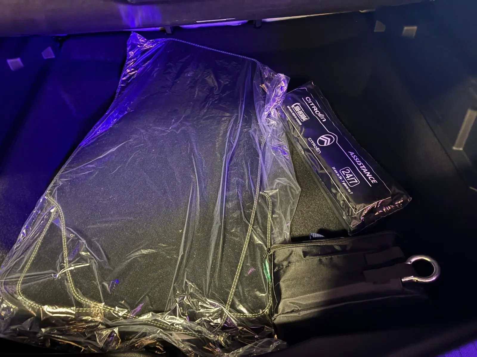 Vue du coffre du Citroën C5 Aircross 2026 vert Astoria Metal avec tapis de sol et kit d'assistance emballés.