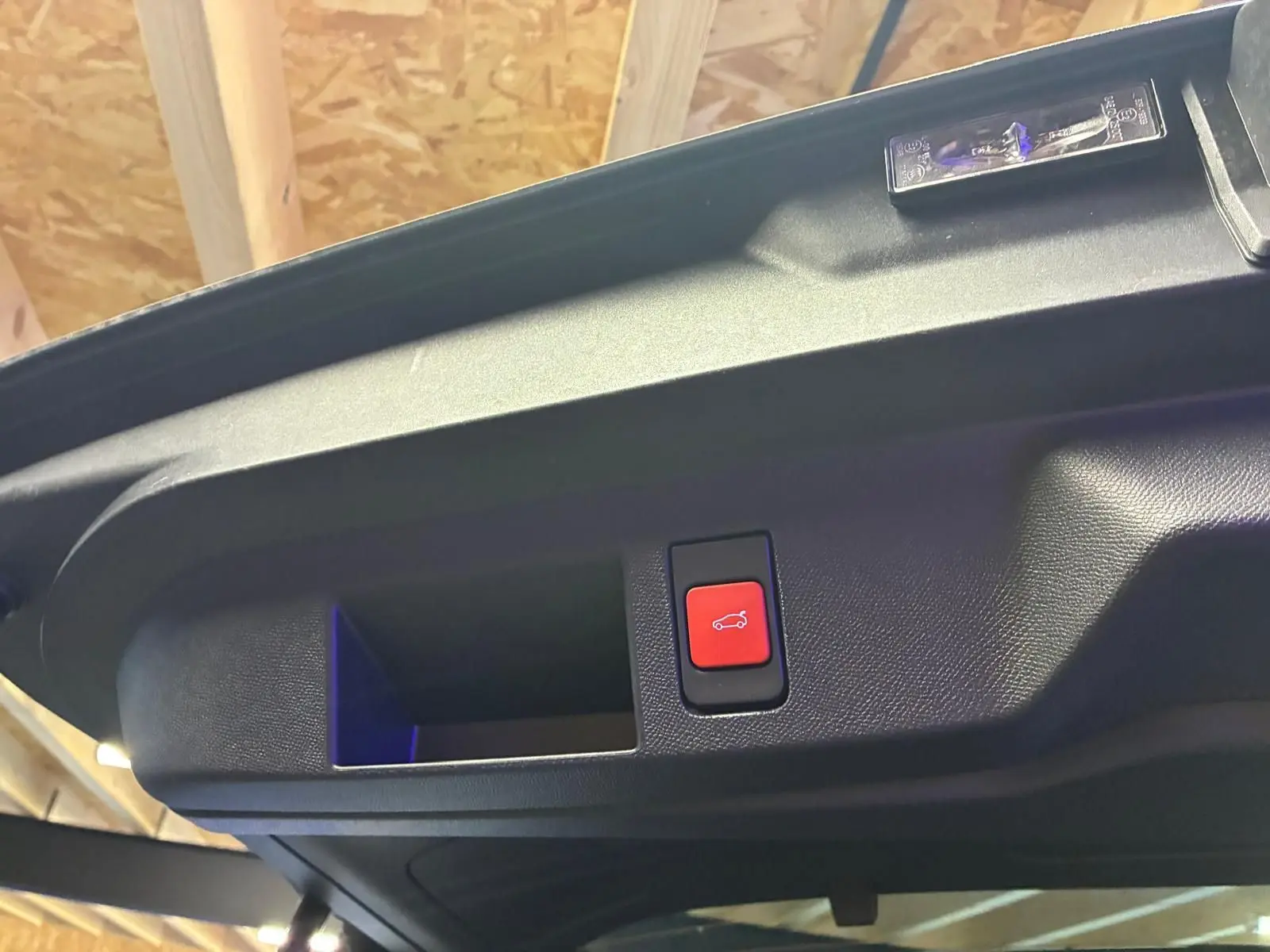 Bouton rouge d'ouverture électrique du coffre sur le hayon intérieur d'un Citroën C5 Aircross 2026 vert Astoria Metal.