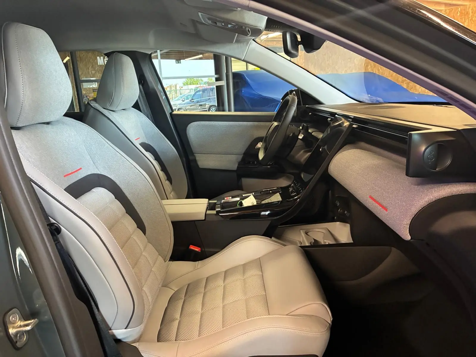Vue intérieure côté conducteur de la Citroën C5 Aircross 2026, sièges gris clair avec détails rouges et tableau de bord épuré.