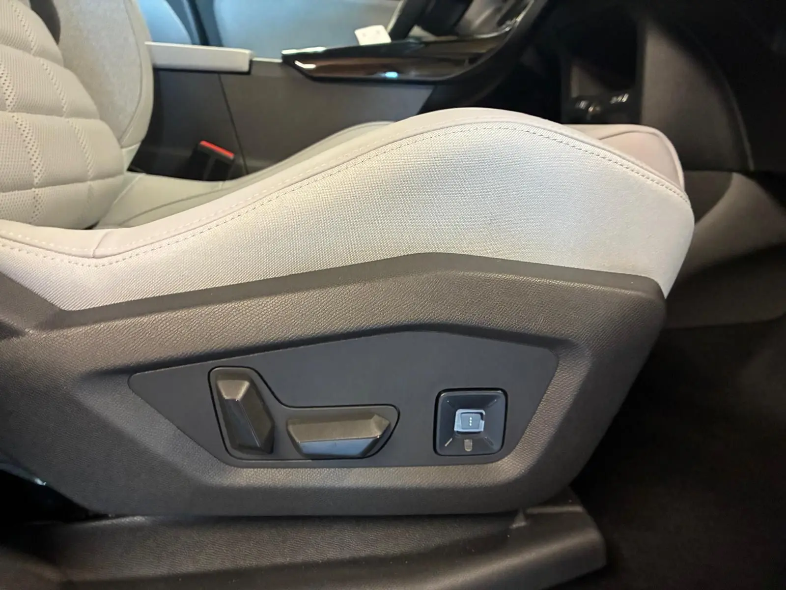 Gros plan sur les commandes électriques du siège avant gris clair dans l'habitacle du Citroën C5 Aircross 2026.