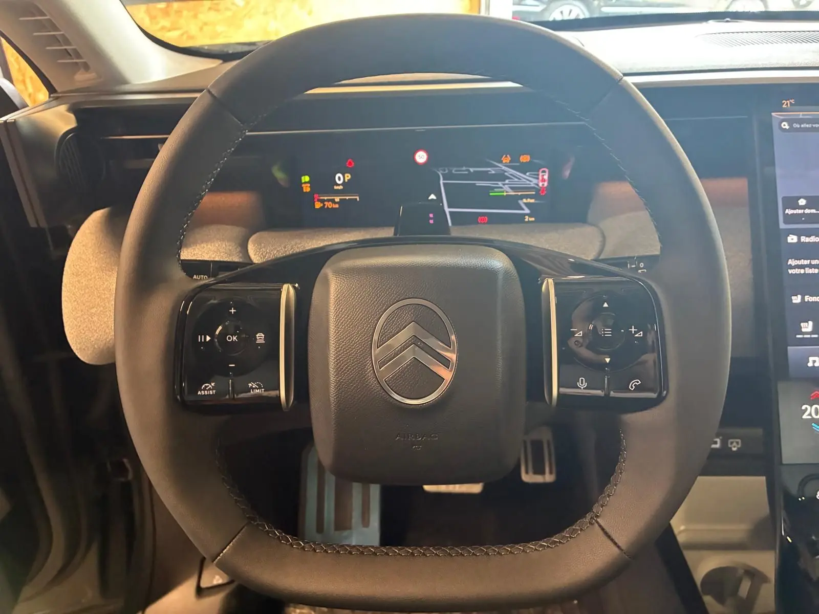 Vue rapprochée du volant du Citroën C5 Aircross 2026, avec commandes intégrées et affichage numérique derrière.