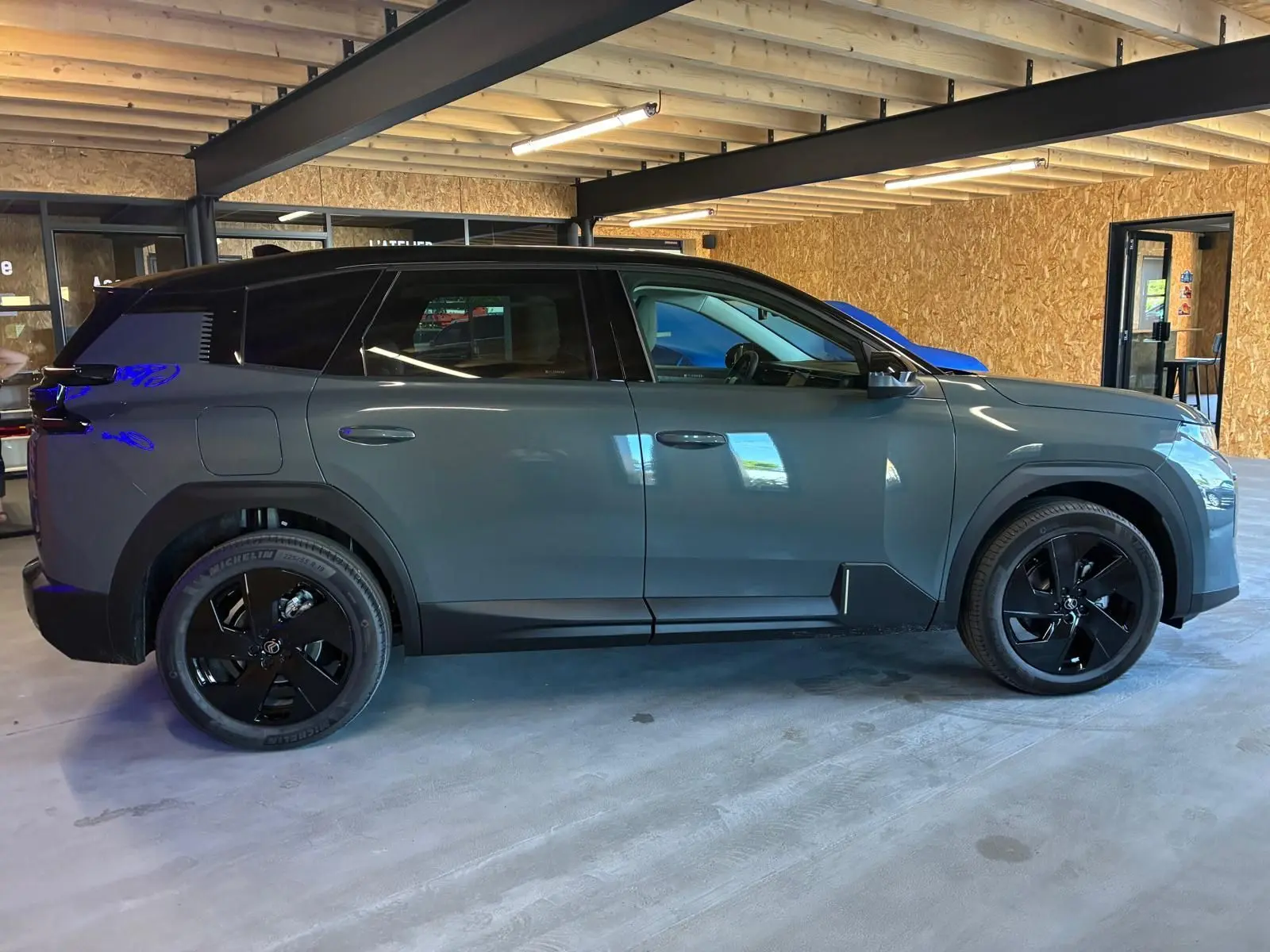 Vue latérale droite d'un Citroën C5 Aircross 1.2 Hybrid 145 BVA Max vert Astoria métal avec jantes noires en intérieur.