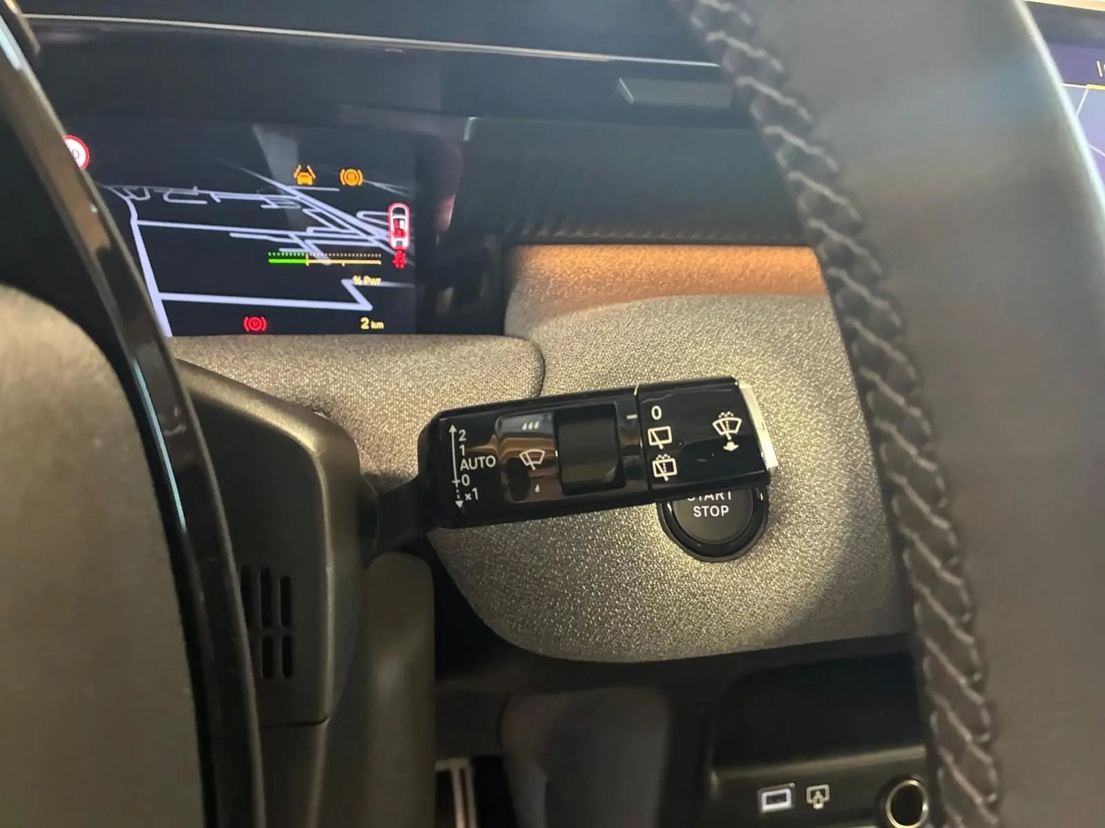 Gros plan sur la commande d’essuie-glace à gauche du volant dans le tableau de bord du Citroën C5 Aircross hybride.
