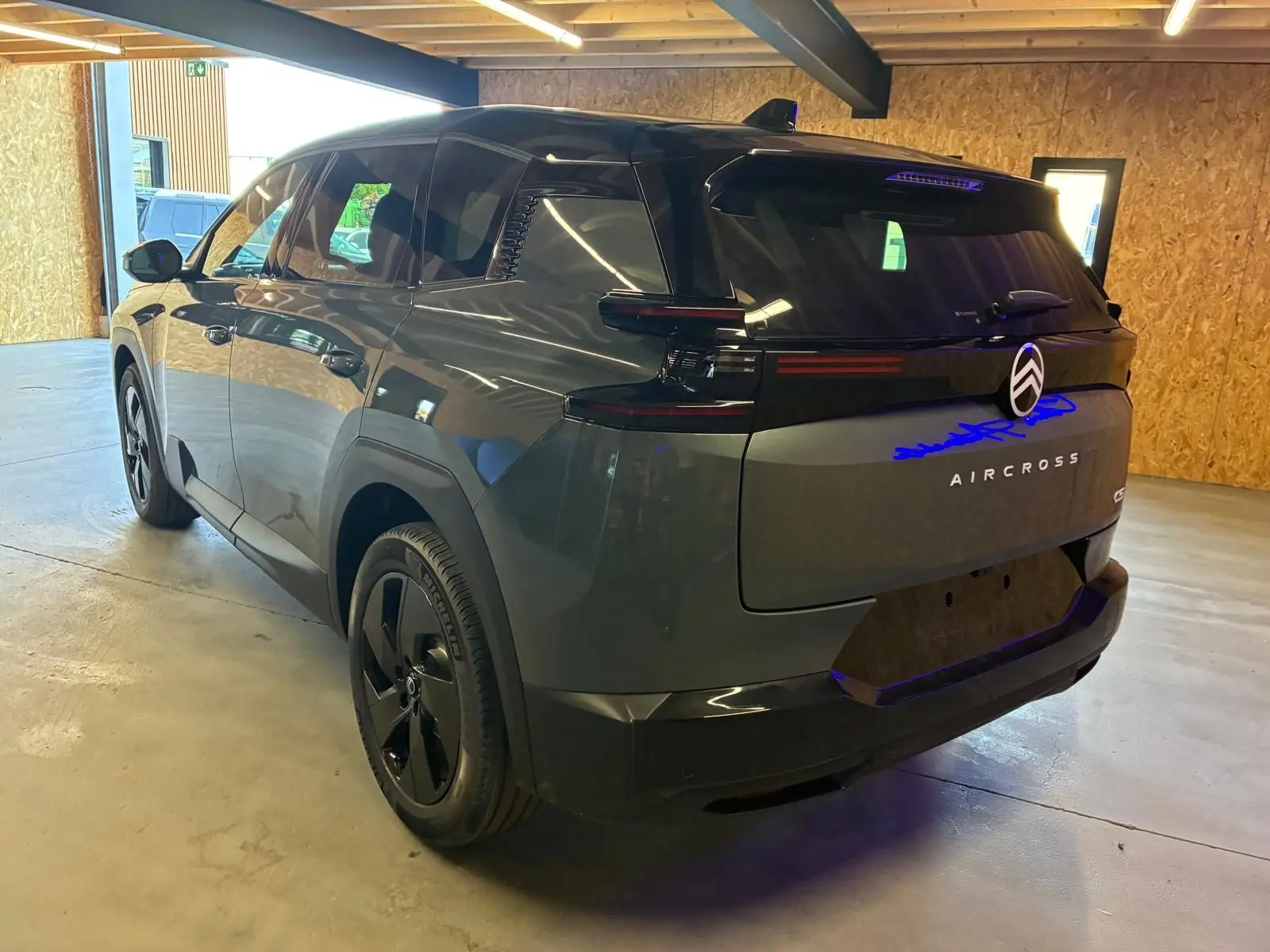 Vue 3/4 arrière droite du Citroën C5 Aircross 2026 vert Astoria métallisé avec feux arrière noirs et jantes noires.