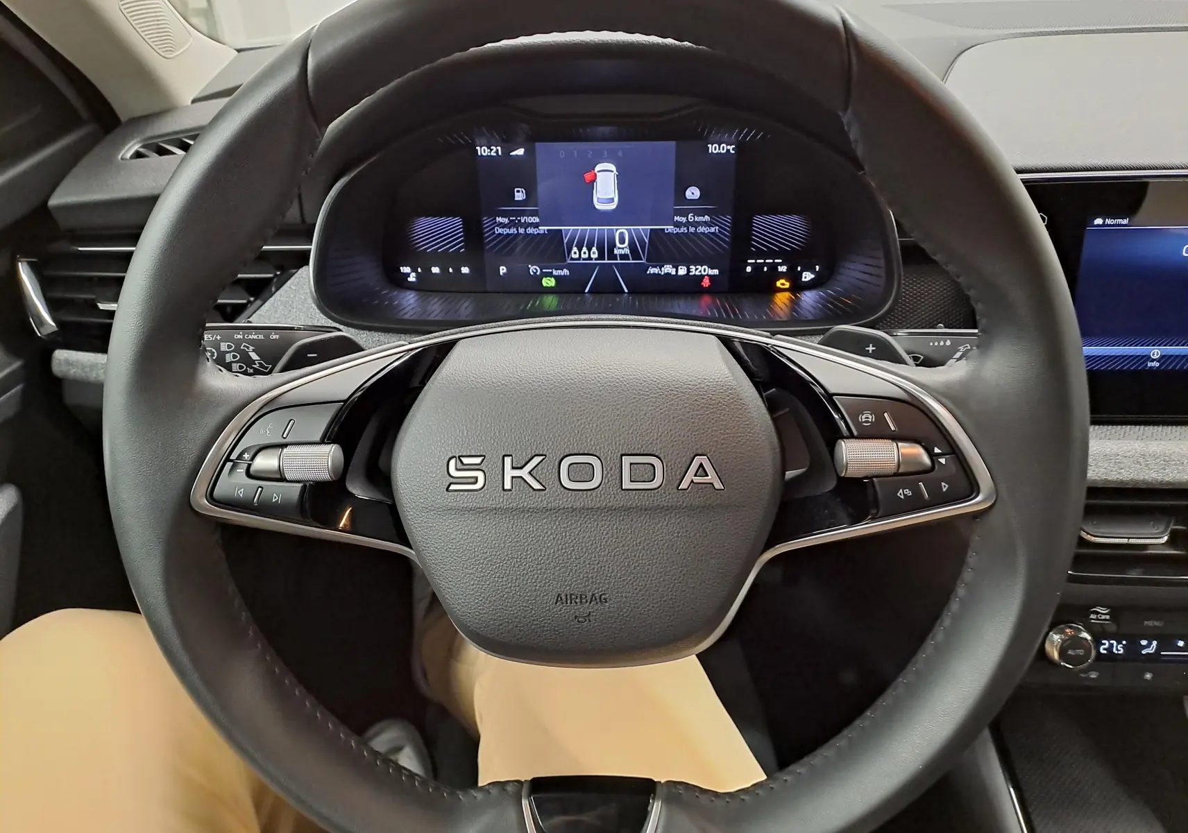 Vue rapprochée du volant SKODA KAMIQ 2025 avec tableau de bord numérique et commandes intégrées, intérieur noir.