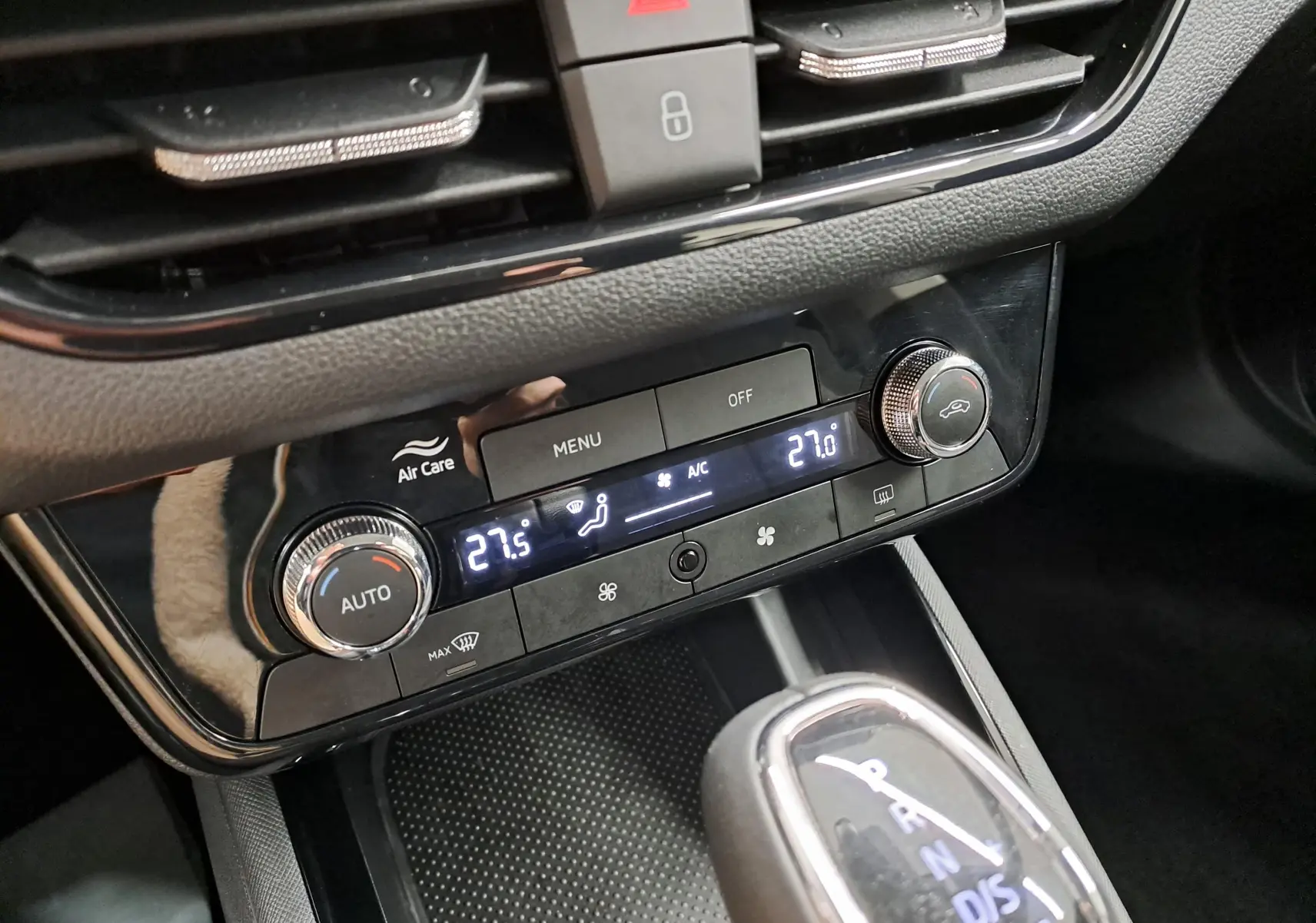 Gros plan sur la console centrale noire du Skoda Kamiq 2025, avec commandes climatisation digitale et levier de boîte automatique.