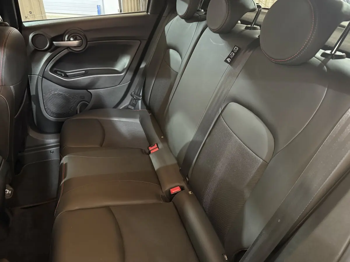 Banquette arrière en cuir noir avec surpiqûres rouges du Fiat 500X, vue côté droit intérieur du véhicule.