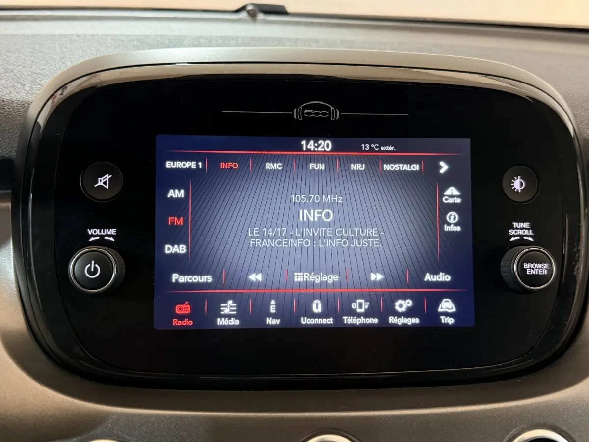 Écran tactile central allumé de la Fiat 500X noire, affichant la radio et les options multimédias.