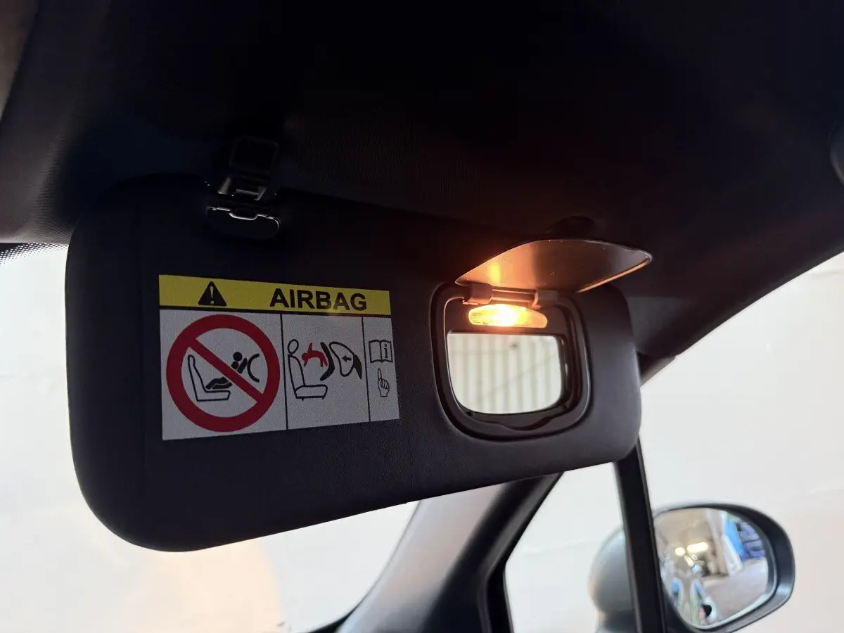 Miroir de courtoisie éclairé sur pare-soleil côté conducteur dans l’habitacle noir du Fiat 500X 2021.