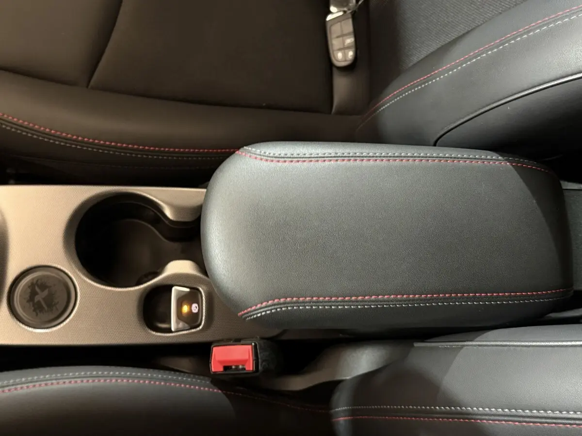 Détail de l'accoudoir central noir avec surpiqûres rouges dans l'habitacle d'une Fiat 500X 2021 Sport.