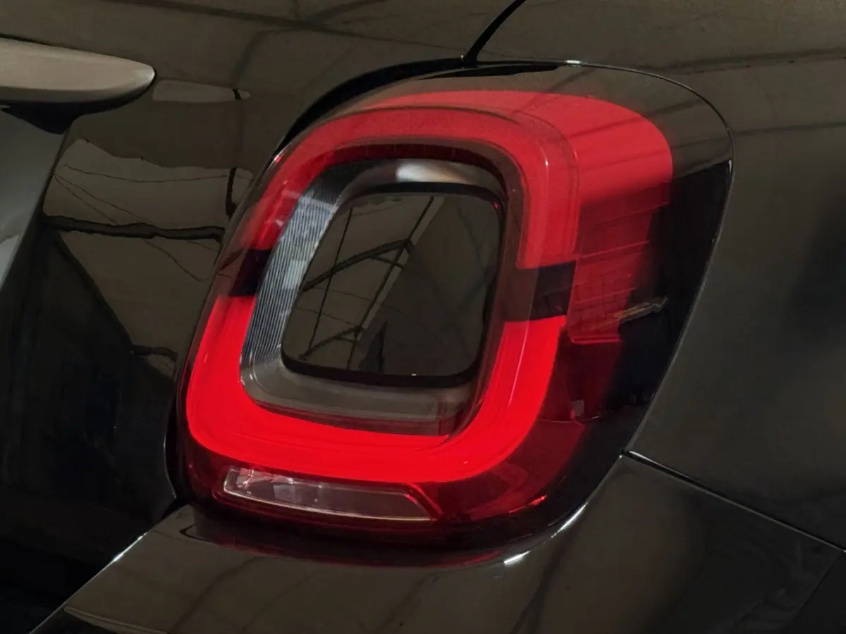Gros plan sur le feu arrière droit rouge d'une FIAT 500X noire, soulignant son design moderne et épuré.