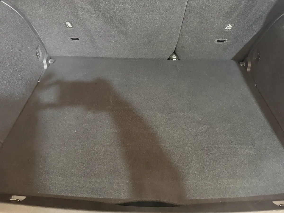 Coffre noir spacieux du Fiat 500X 2021, vue intérieure arrière avec banquette rabattue partiellement visible.