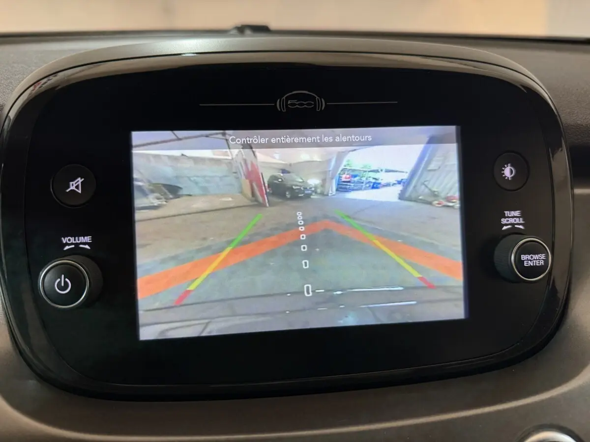 Écran tactile du tableau de bord de la Fiat 500X noir montrant la caméra de recul avec guidage coloré.