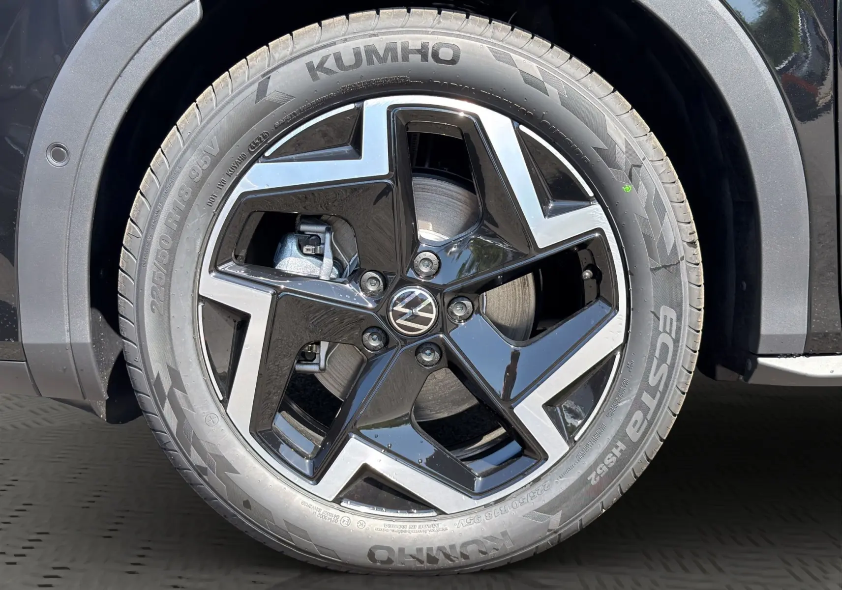 Gros plan sur la roue avant droite noire et argentée du Volkswagen T-Roc 2026 noir ébène avec jante en alliage et pneu Kumho.