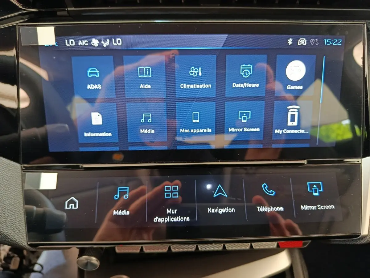 Écran tactile central du tableau de bord de la Peugeot 308 blanche, affichant les menus multimédias et navigation.