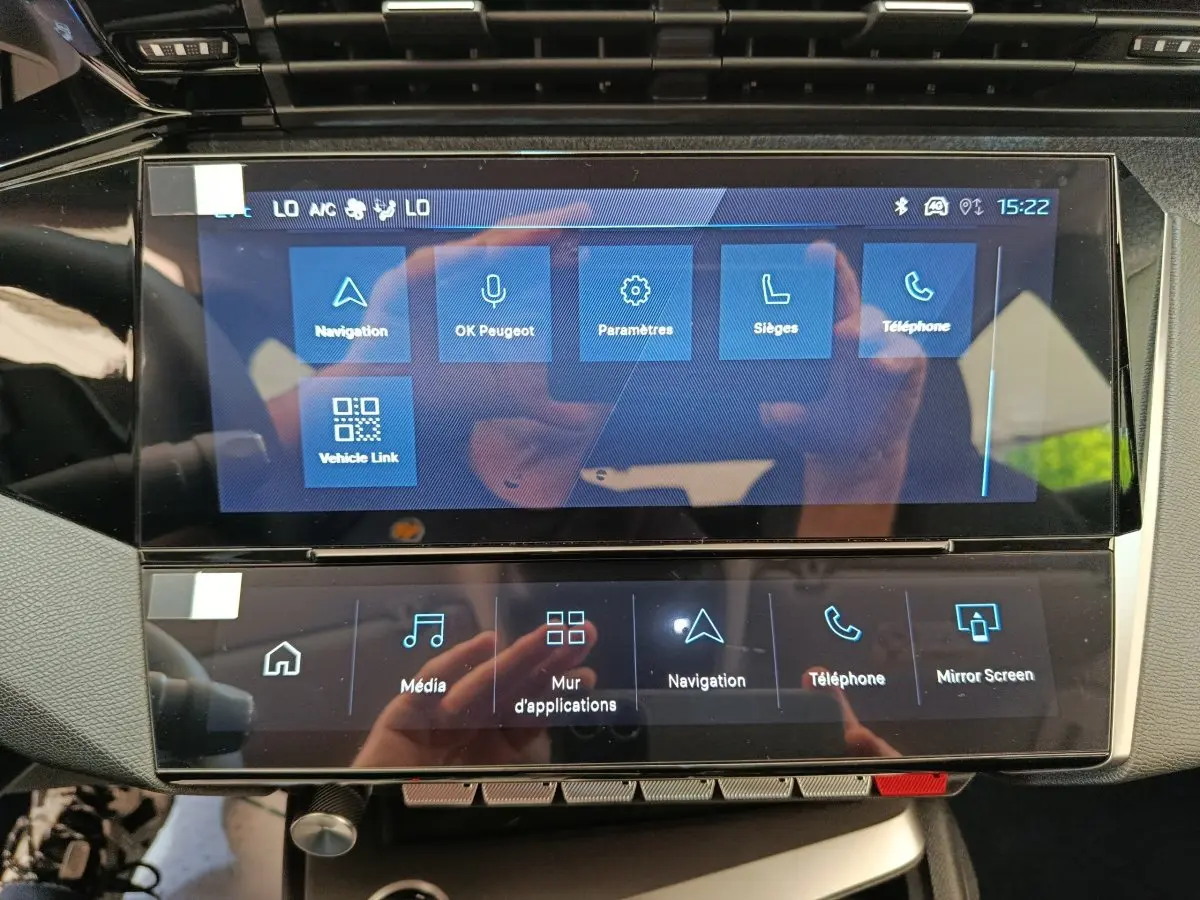 Écran tactile central de la Peugeot 308 blanc, affichant le menu principal avec options navigation et téléphone.
