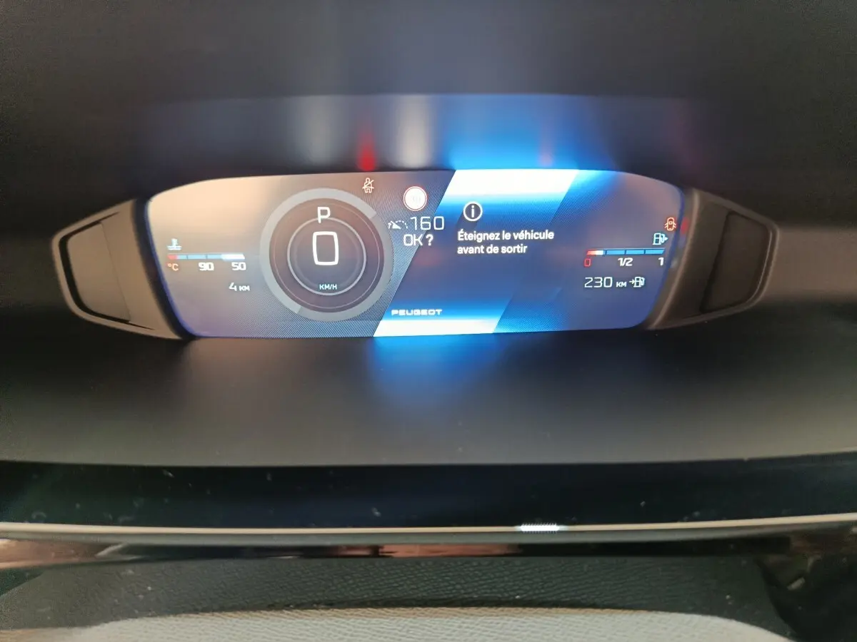 Affichage numérique du combiné d'instruments de la Peugeot 308 2026, avec indication vitesse, autonomie et message d'arrêt véhicule.