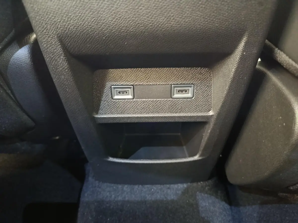 Vue rapprochée de la console arrière noire avec deux ports USB-C et un rangement sur Peugeot 308 blanc 2026.