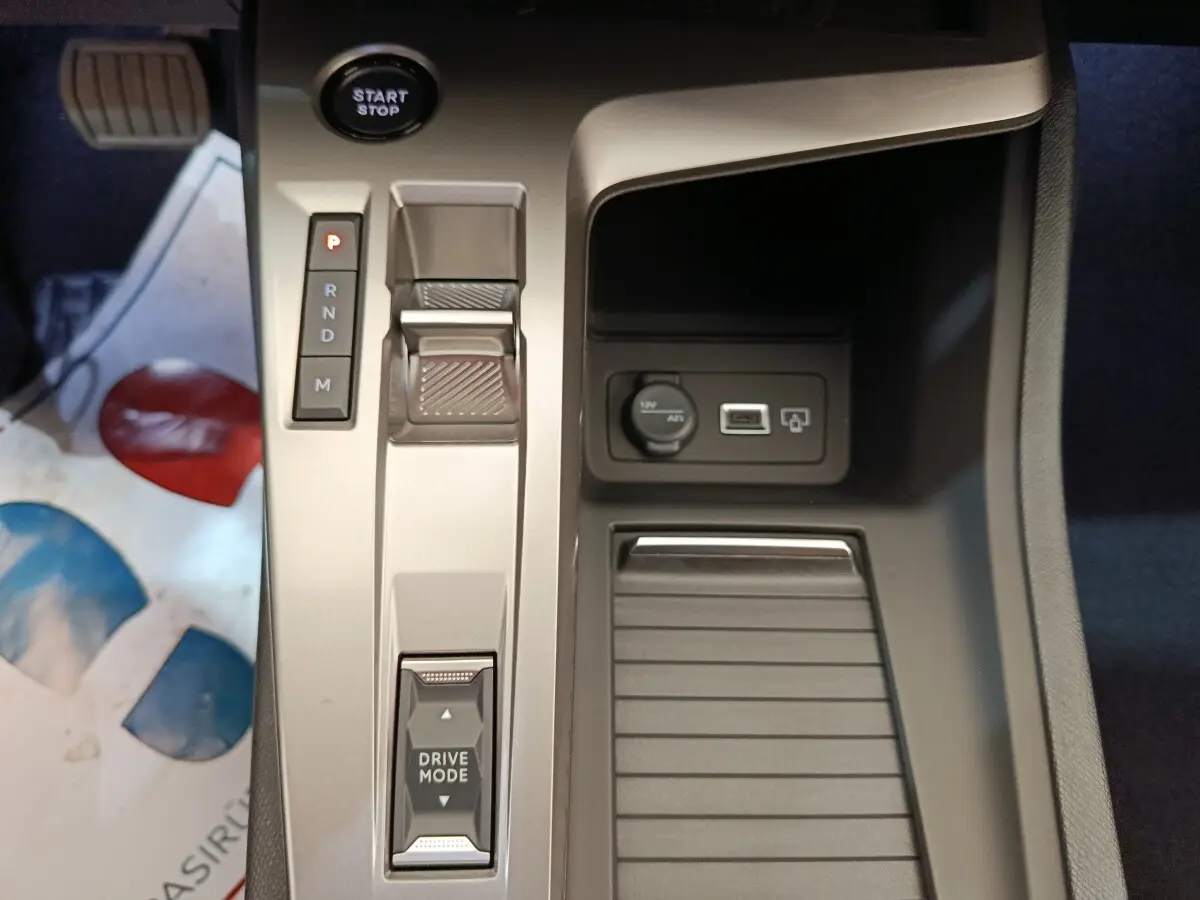 Vue plongeante sur la console centrale de la Peugeot 308 blanche, avec bouton start/stop et sélecteur de boîte automatique.