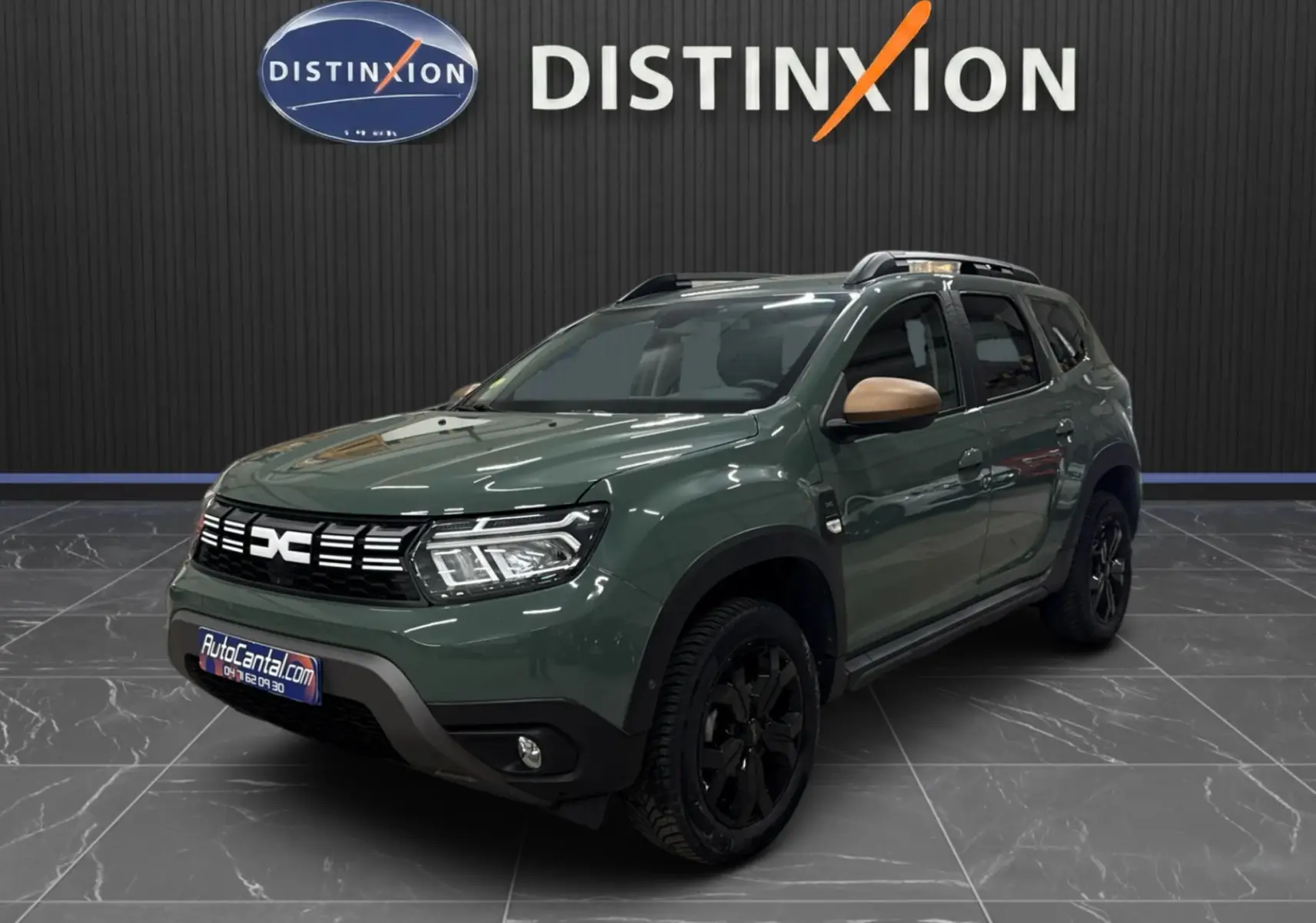 Dacia Duster 2024 kaki lichen en 3/4 avant droit, avec jantes noires et rétroviseurs couleur bronze.