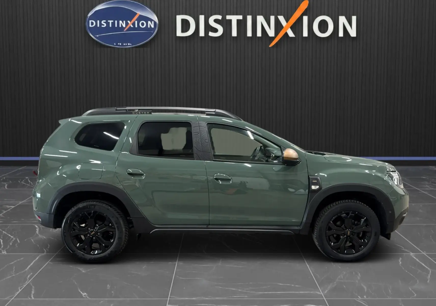 Profil gauche du Dacia Duster 2024 kaki lichen avec jantes noires et rétroviseur couleur bronze.