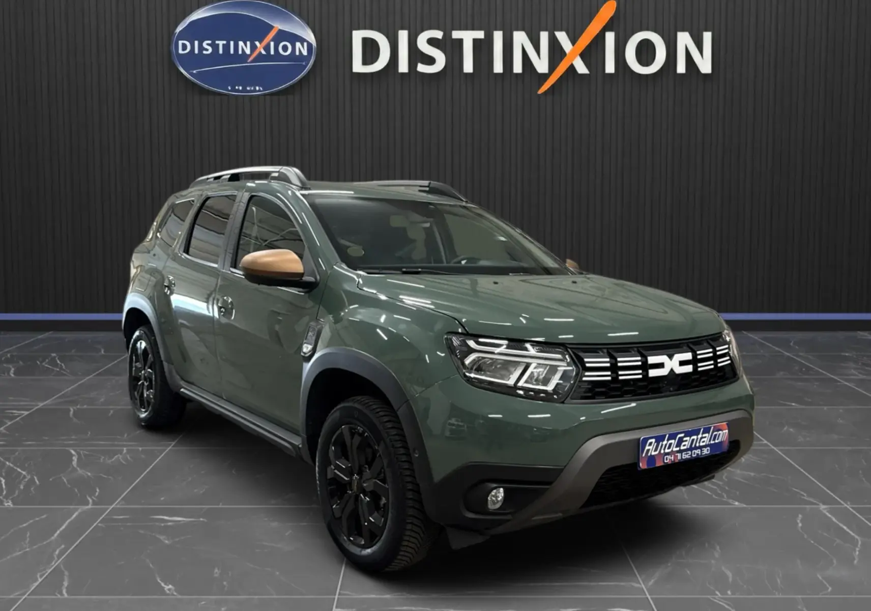 Dacia Duster 2024 kaki lichen en 3/4 avant droit, avec rétroviseurs marron et jantes noires distinctives.