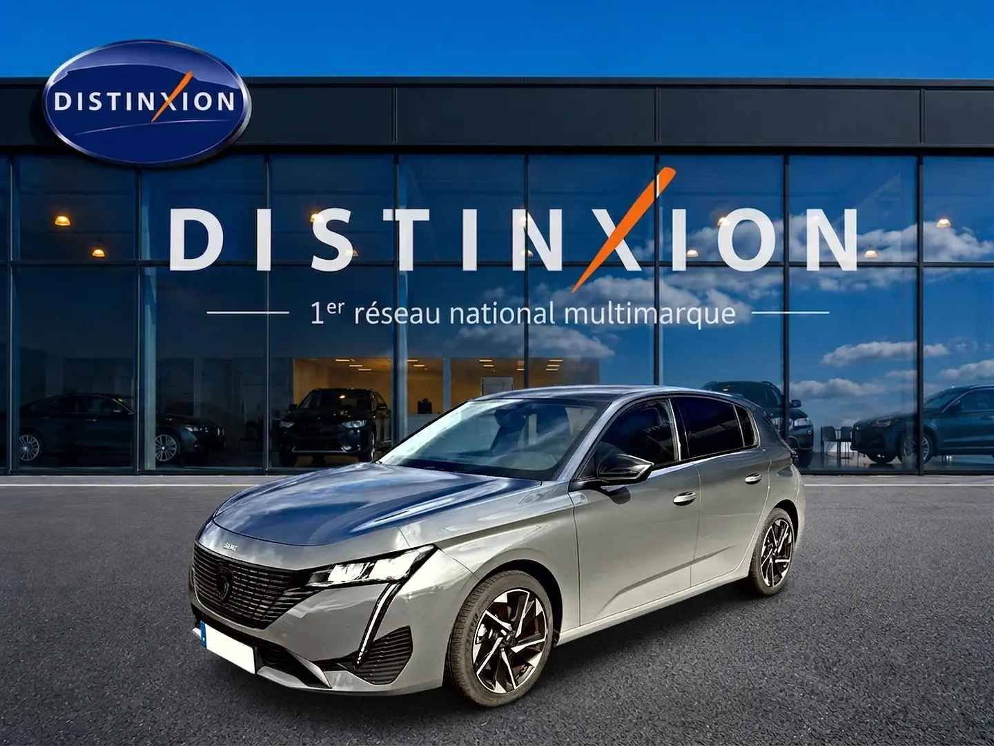 Peugeot 308 gris selenium vue 3/4 avant droit, avec jantes alliage et calandre noire distinctive.