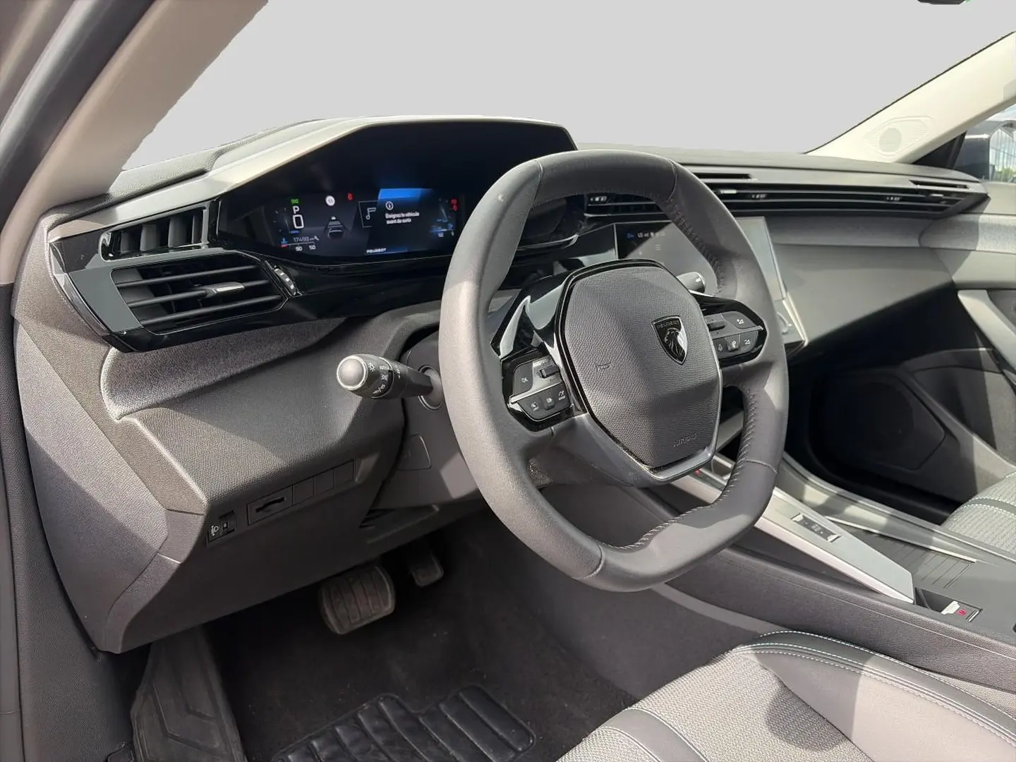 Intérieur de la Peugeot 308 2025 vue côté conducteur, volant multifonction et tableau de bord numérique.