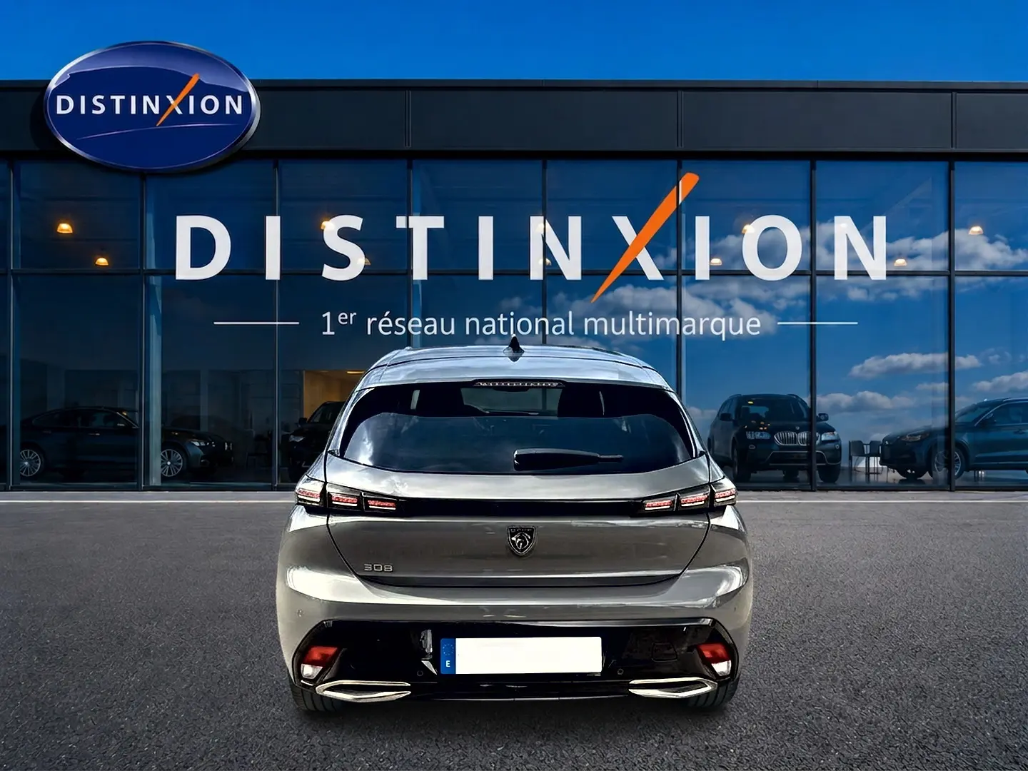 Vue arrière d'une Peugeot 308 gris selenium 2025 avec feux LED et double sortie d'échappement chromée.