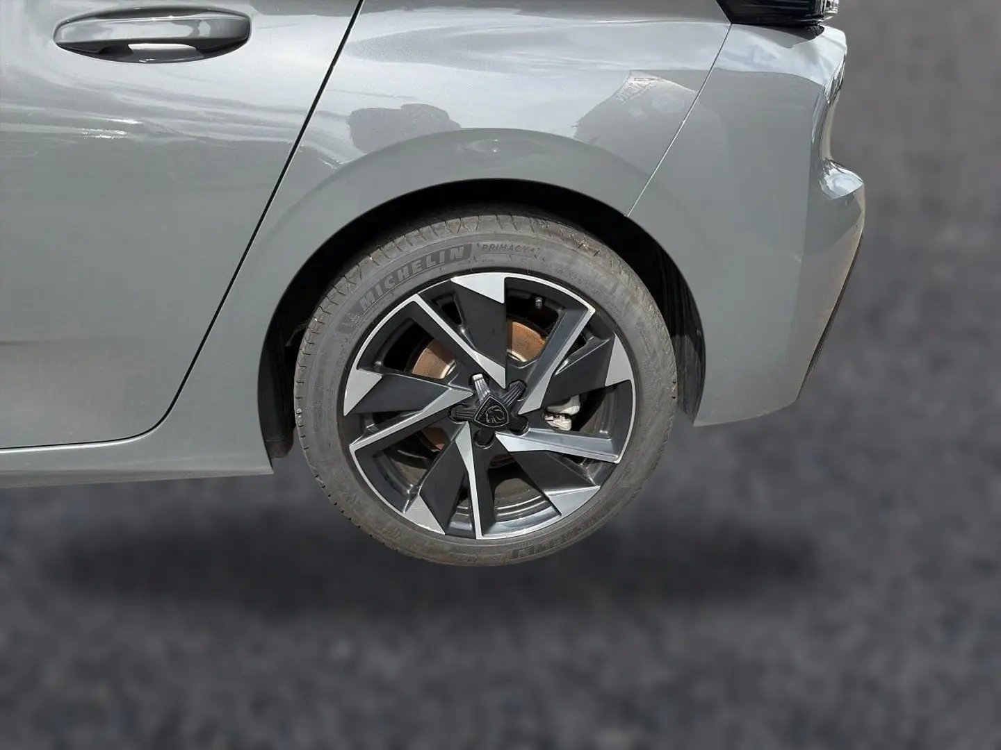 Gros plan sur la roue arrière droite d'une Peugeot 308 gris selenium, mettant en valeur la jante alu au design moderne.