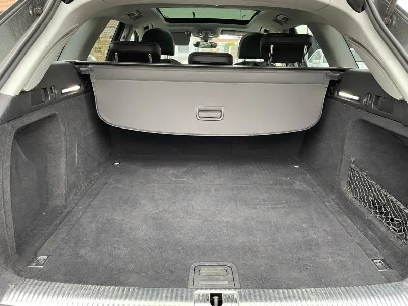 Coffre spacieux et propre d'une Audi A4 Avant 40 TFSI 2019, avec cache-bagages gris et banquette arrière noire visible.