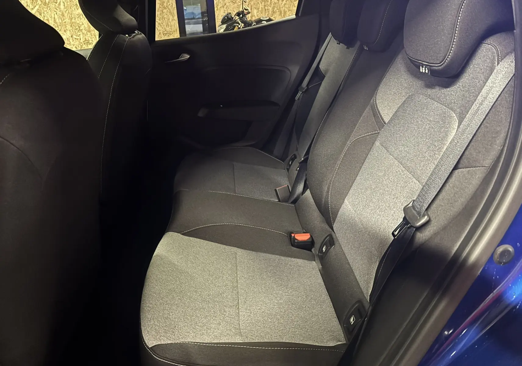 Vue intérieure côté droit des sièges arrière en tissu gris et noir de la Renault Clio TCe 90ch Evolution 2024 bleu Iron.