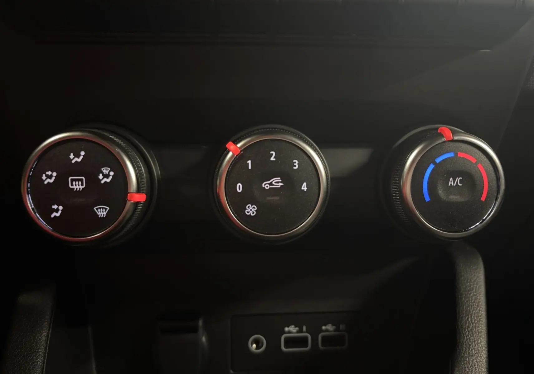 Gros plan sur les commandes de climatisation de la Renault Clio 2024 bleu Iron, avec réglages ventilation, air et température.