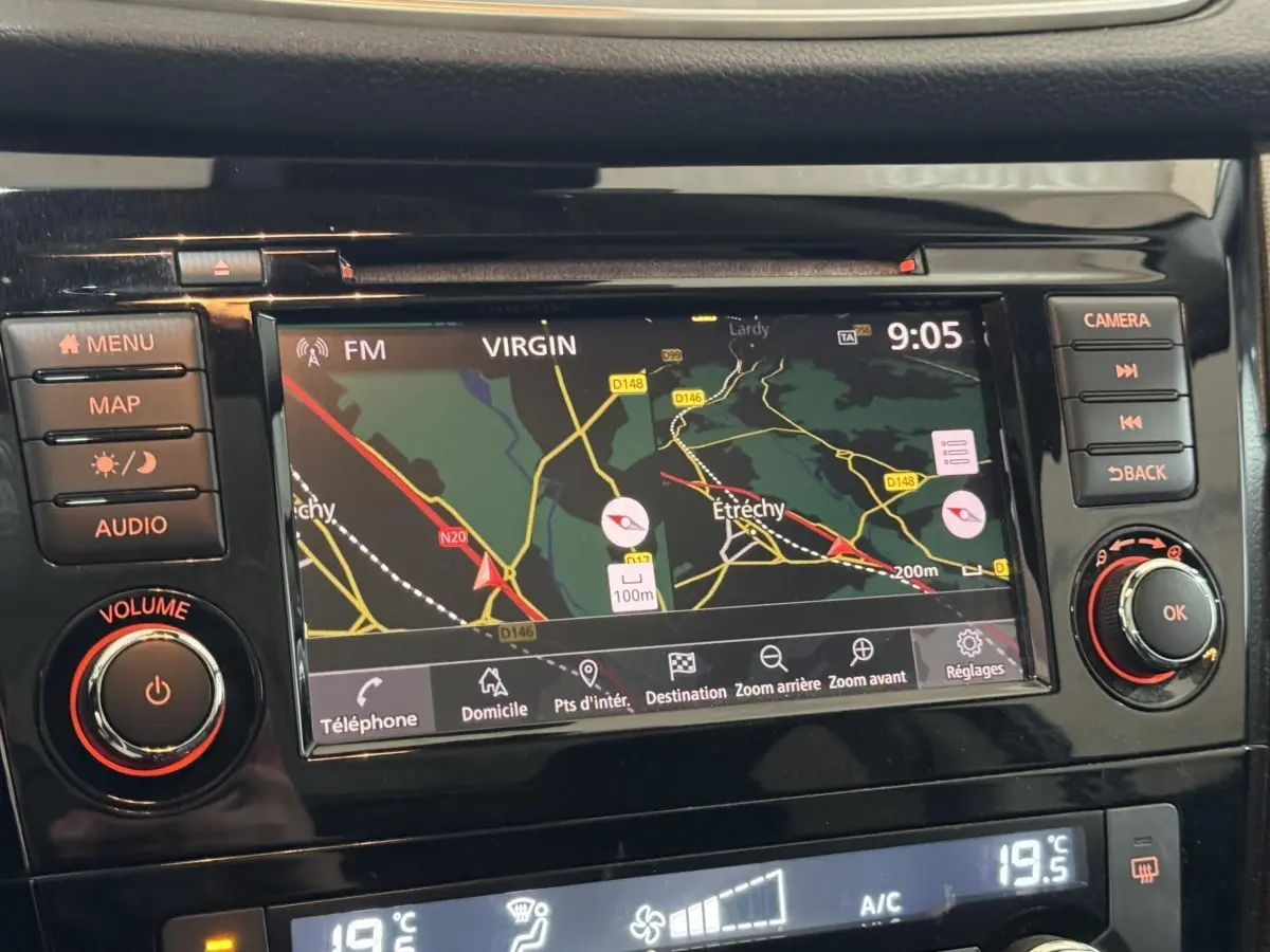 Vue rapprochée de l’écran tactile de navigation et des commandes noires du tableau de bord du Nissan Qashqai gris foncé.