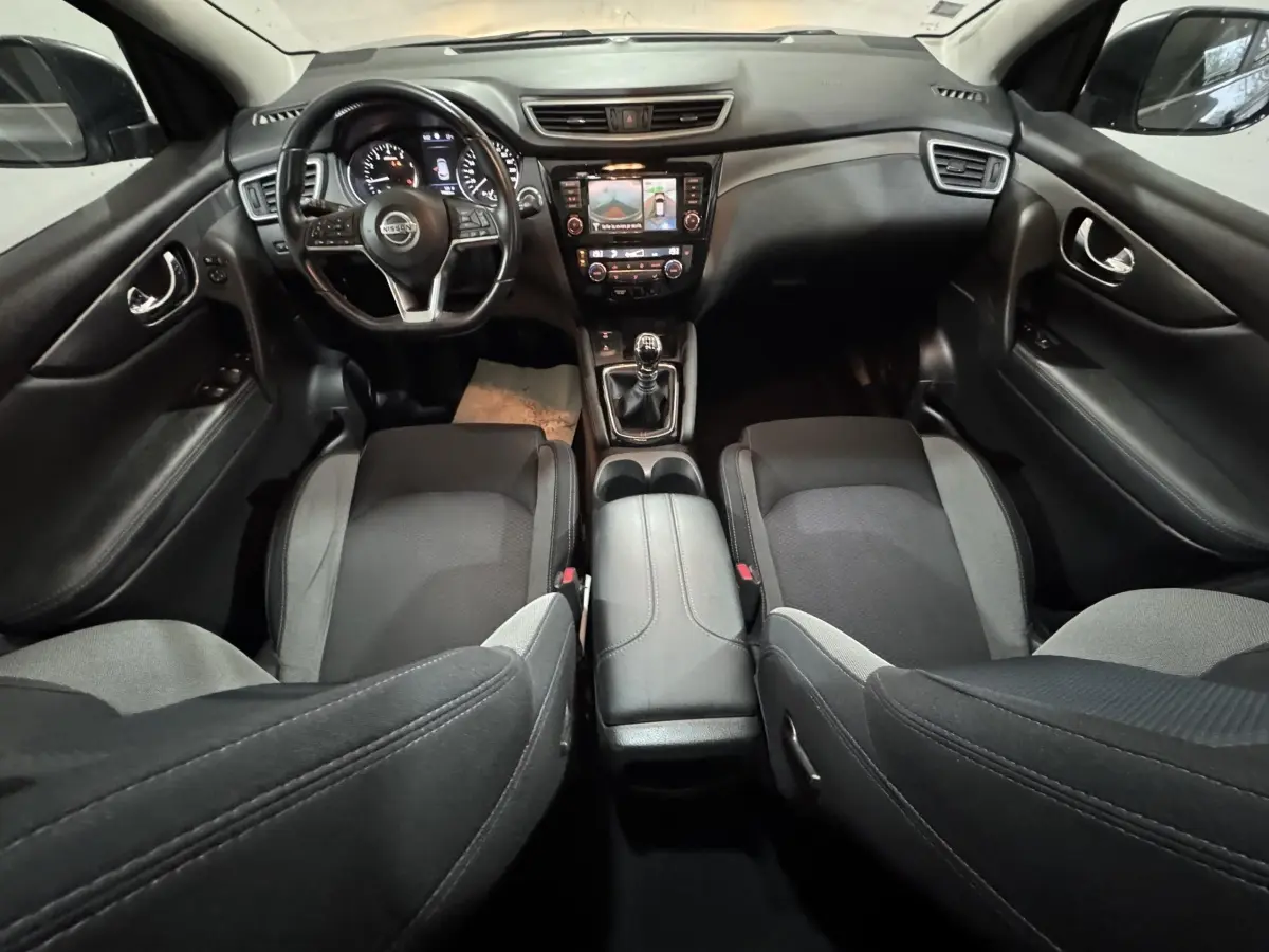 Intérieur noir et gris du Nissan Qashqai 2019, vue avant centrée sur le tableau de bord et volant multifonctions.