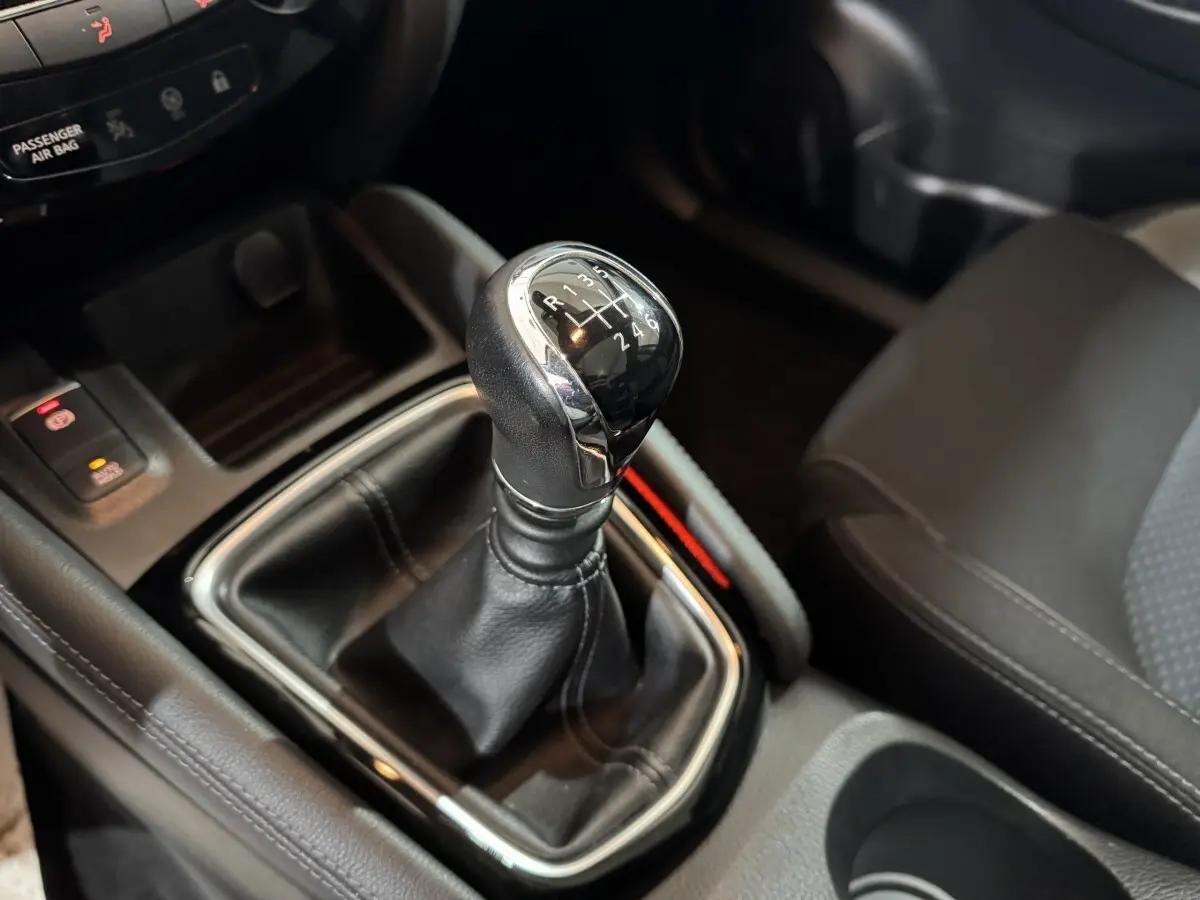 Gros plan sur le levier de vitesses manuel en cuir noir du Nissan Qashqai 2019, intérieur gris foncé.