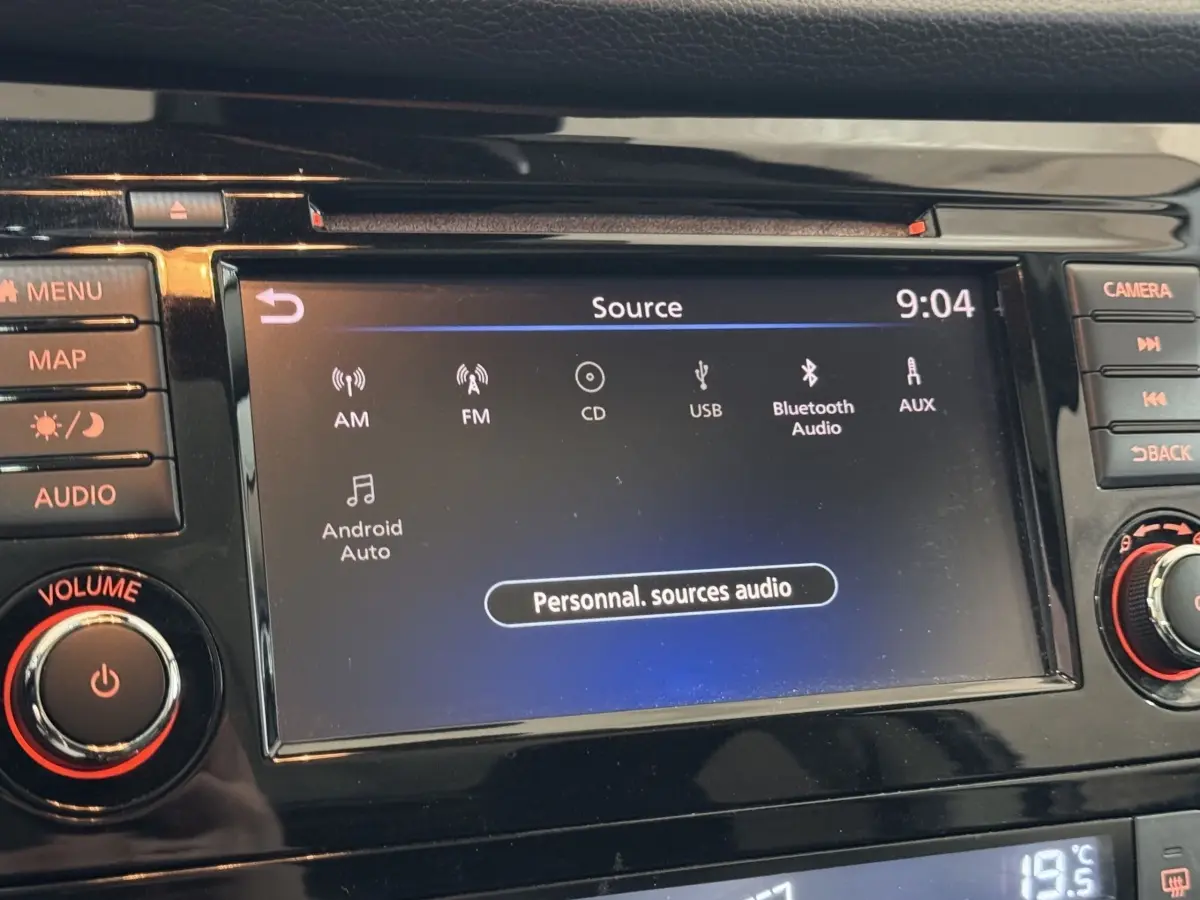 Écran tactile central du Nissan Qashqai 2019 affichant les sources audio, entouré de boutons de commande noirs.