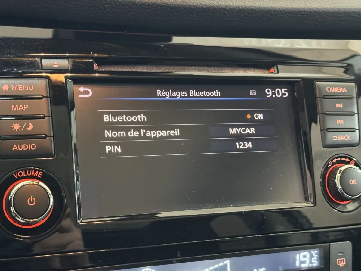 Écran tactile central du Nissan Qashqai 2019 affichant les réglages Bluetooth, entouré de boutons noirs avec marquages orange.