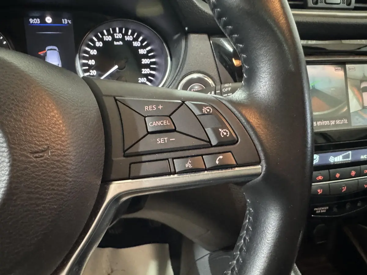 Gros plan sur le volant cuir alu du Nissan Qashqai 2019 avec commandes multifonctions et tableau de bord partiel visible.