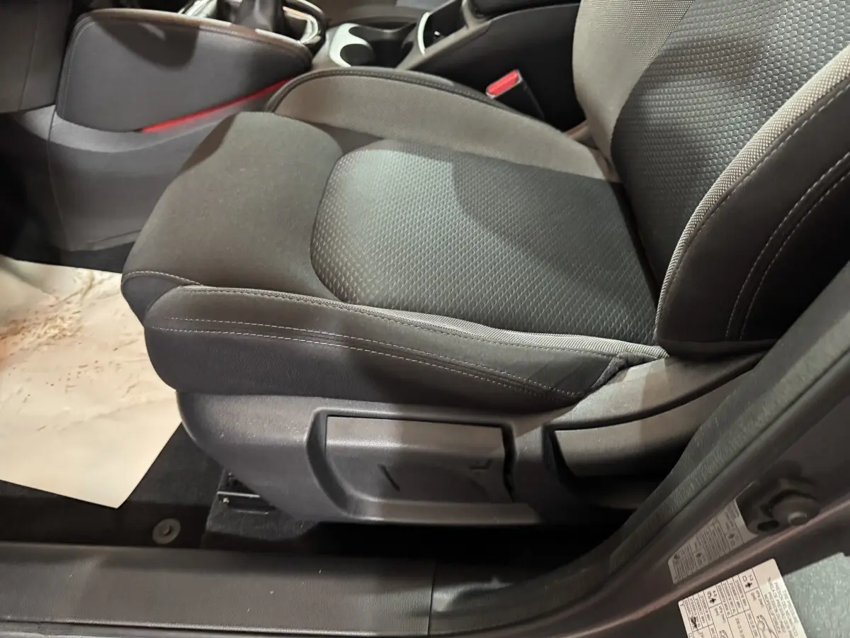 Gros plan sur le siège avant droit tissu gris foncé du Nissan Qashqai 2019, avec réglage manuel visible.